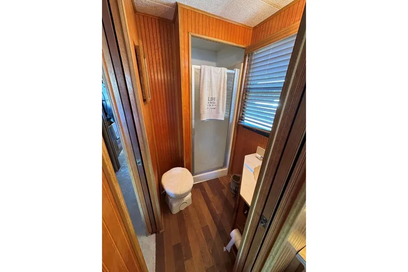 Slide: The Image of 1987 Stardust Cruisers bathroom with wood paneling, shower, and toilet. - 33