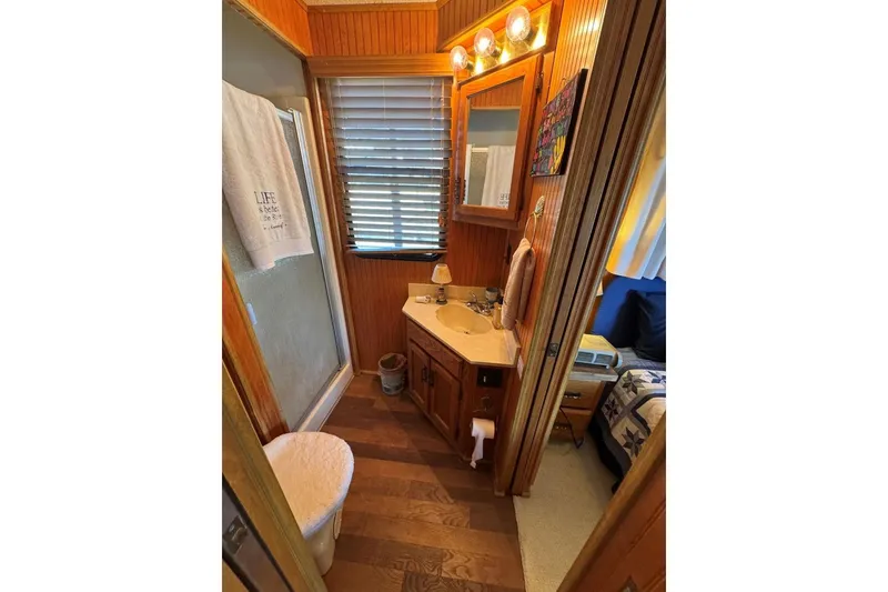 Slide: The Image of Cozy bathroom in 1987 Stardust Cruisers houseboat with wood paneling and vanity. - 34