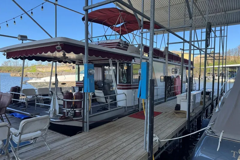 Slide: The Image of 1987 Stardust Cruisers 14 x 54 houseboat docked, featuring outdoor seating and canopy. - 4