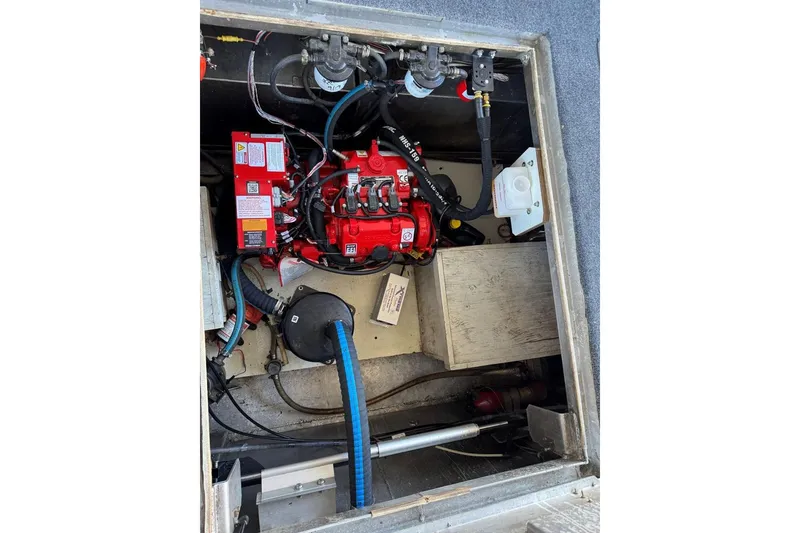 Slide: The Image of Engine compartment of a 1987 Stardust Cruisers 14 x 54 houseboat, featuring red machinery and wiring. - 45