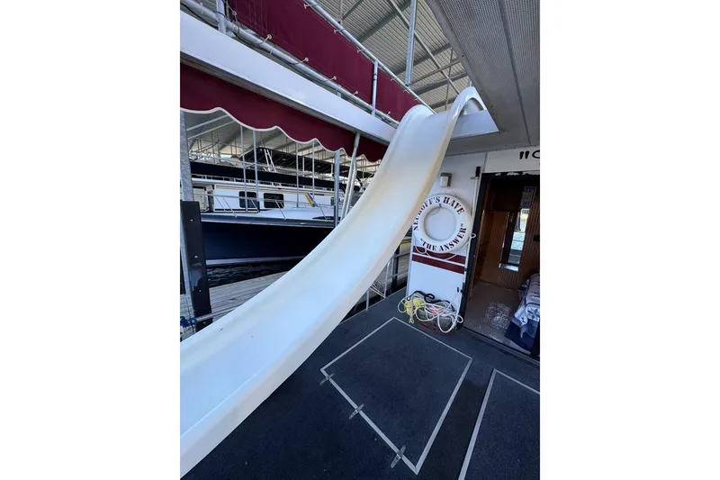 Slide: The Image of Houseboat with slide, Stardust Cruisers 1987 model, docked in marina. - 46