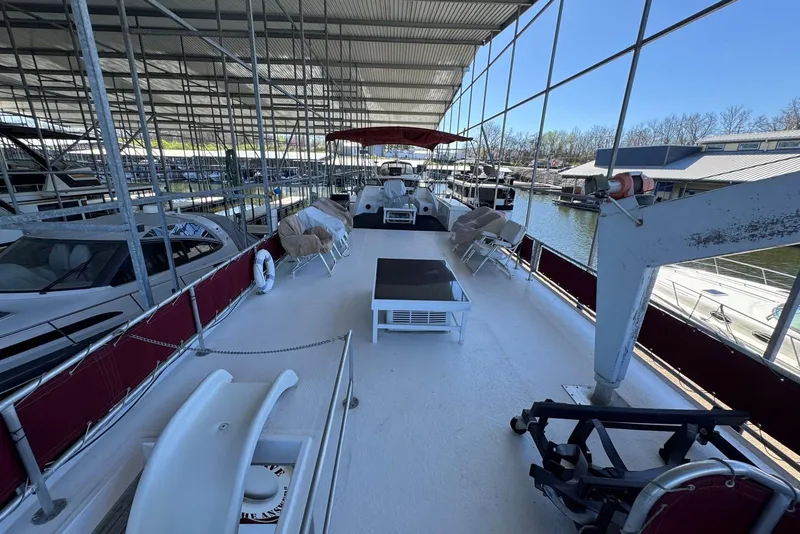 Slide: The Image of 1987 Stardust Cruisers 14 x 54 houseboat docked in a marina, featuring spacious deck area. - 48