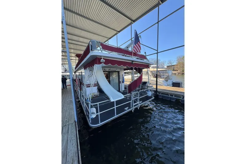 Slide: The Image of 1987 Stardust Cruisers 14 x 54 houseboat with slide, docked under a canopy. - 5