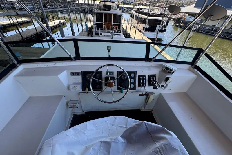 Slide: The Image of 1987 Stardust Cruisers 14 x 54 houseboat helm with steering wheel and controls in marina. - 52