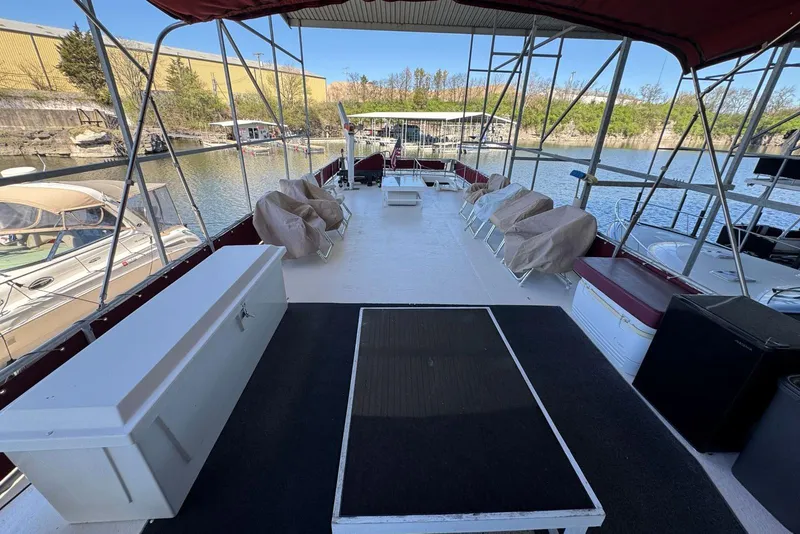 Slide: The Image of 1987 Stardust Cruisers 14 x 54 houseboat deck with covered seating and scenic marina view. - 54