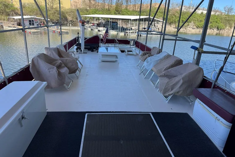 Slide: The Image of 1987 Stardust Cruisers 14 x 54 houseboat deck with covered seating and scenic marina view. - 55