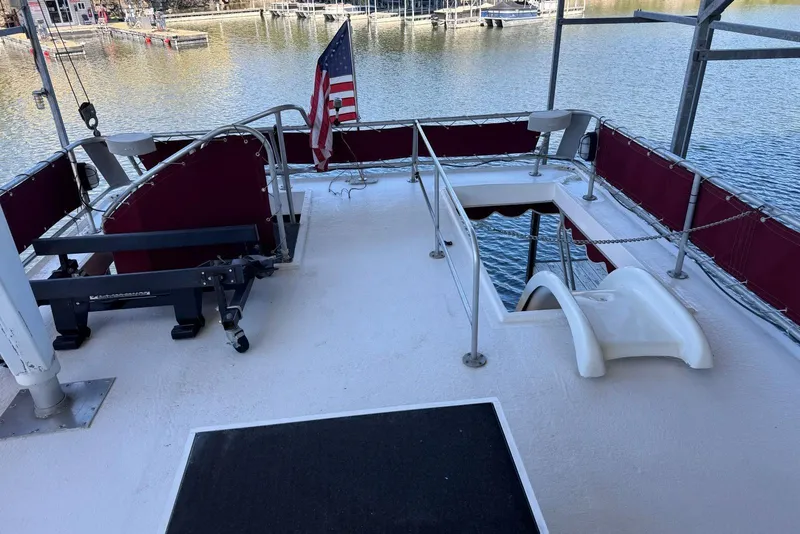 Slide: The Image of Upper deck of 1987 Stardust Cruisers houseboat with American flag and water view. - 56