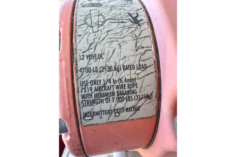 Slide: The Image of Label on equipment showing specifications for 12V DC, 4700 lb load, and wire rope use. - 58