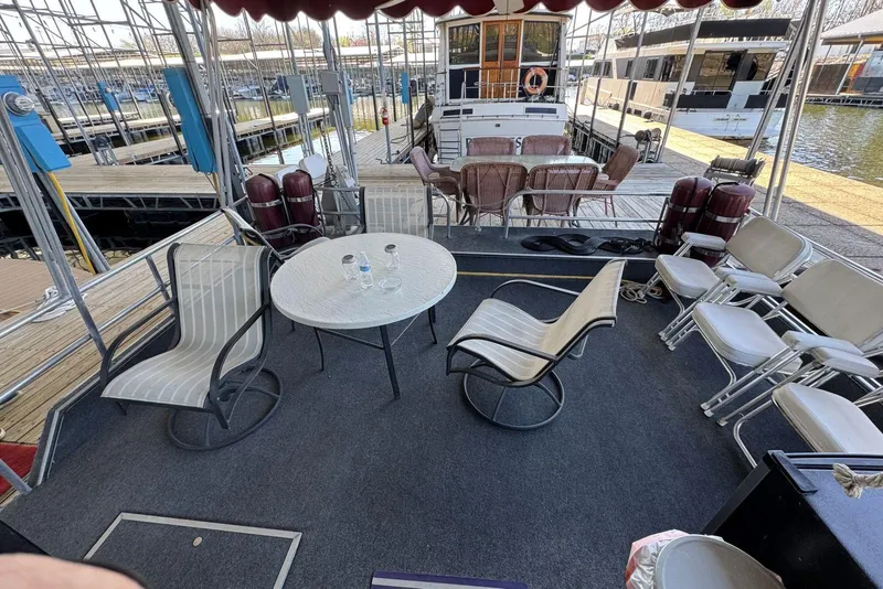 Slide: The Image of 1987 Stardust Cruisers 14 x 54 houseboat deck with chairs and table at marina. - 7