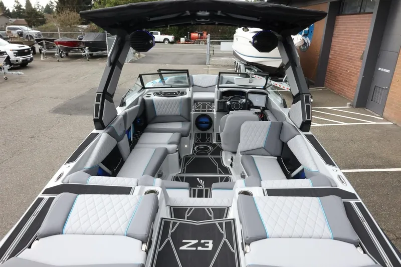 Slide: The Image of 2026 Tigé Z3 boat interior with modern seating and sleek design in a showroom setting. - 11