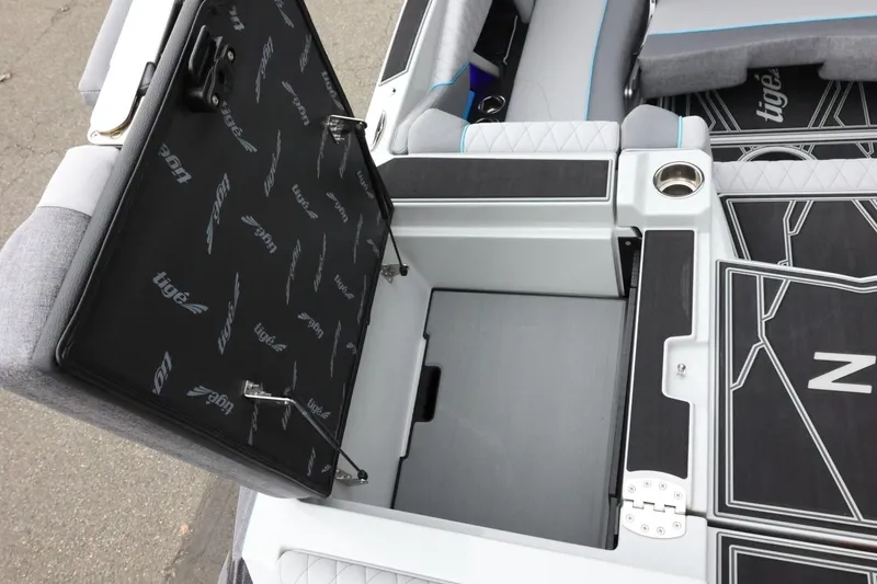 Slide: The Image of 2026 Tigé Z3 boat interior storage compartment with open lid and cup holder. - 51