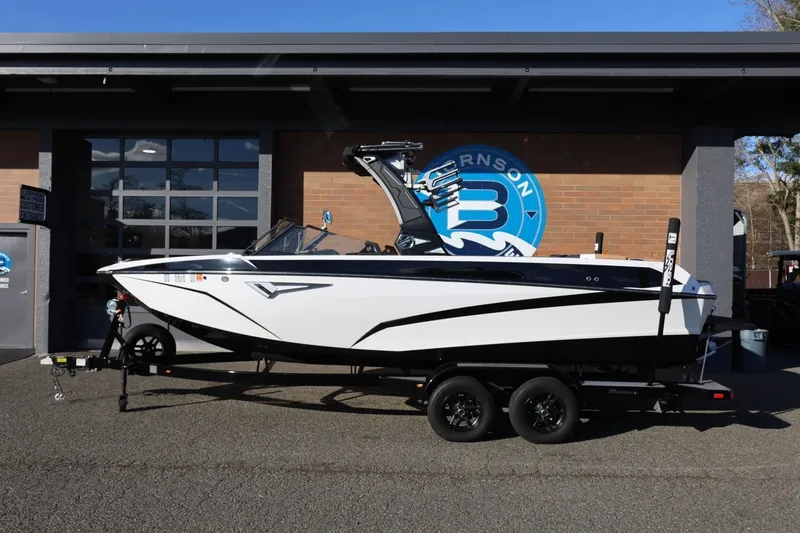 The Image of 2023 Tigé Z3 boat on trailer, parked outside a building with a blue logo. - 1