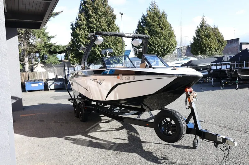 Slide: The Image of 2023 Tigé Z3 boat on trailer in outdoor setting, surrounded by trees and buildings. - 10