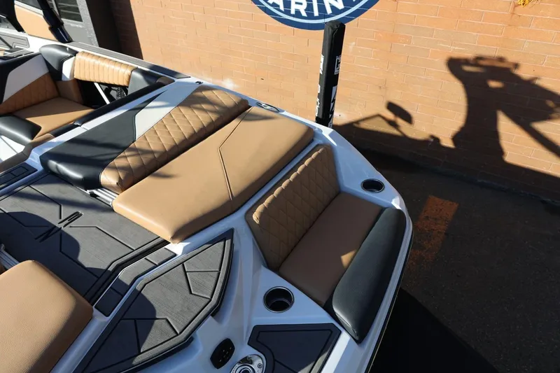 Slide: The Image of 2023 Tigé Z3 boat interior with tan and black seating, cup holders, and quilted design. - 17