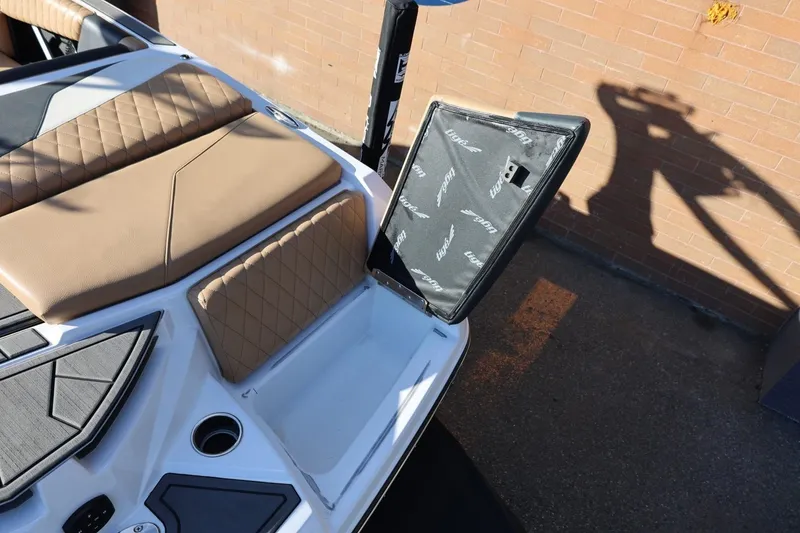 Slide: The Image of 2023 Tigé Z3 boat interior with open storage compartment and tan seating. - 19