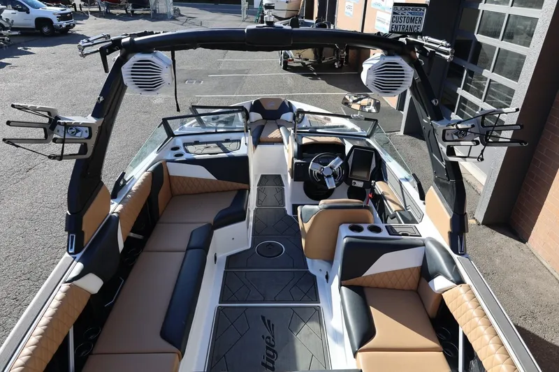 Slide: The Image of 2023 Tigé Z3 boat interior with tan and black seating, advanced dashboard, and wakeboard racks. - 24