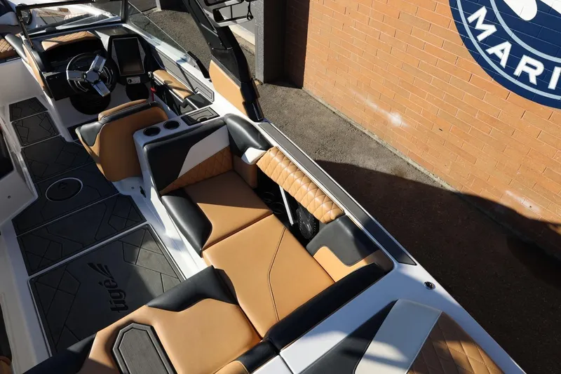 Slide: The Image of 2023 Tigé Z3 boat interior with tan and black seating, near a brick wall. - 26
