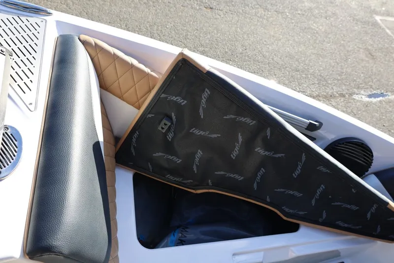 Slide: The Image of 2023 Tigé Z3 boat interior with cushioned seating and branded storage cover. - 47