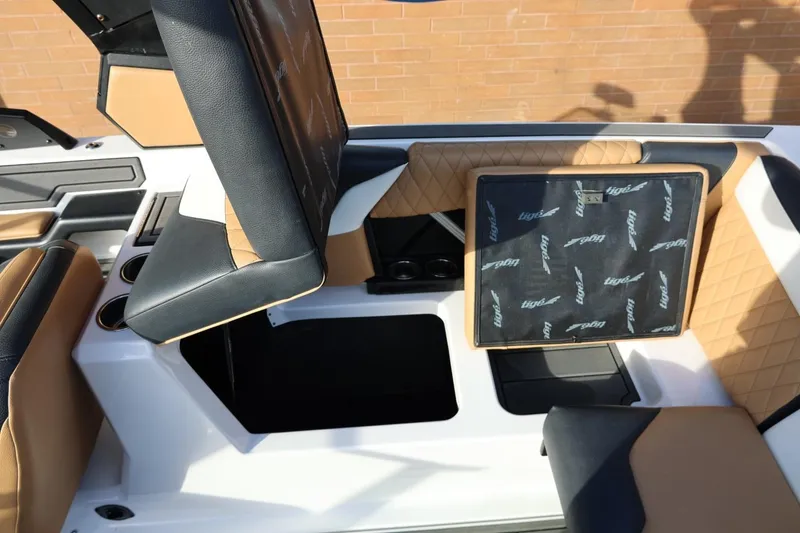 Slide: The Image of 2023 Tigé Z3 boat interior with tan and black seating, showcasing storage compartments. - 49
