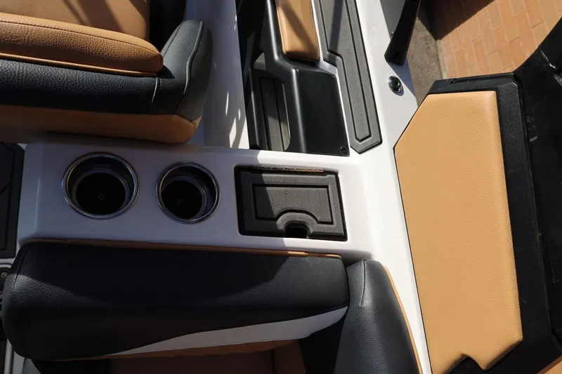 Slide: The Image of 2023 Tigé Z3 boat interior with tan and black seating, cup holders, and storage compartment. - 52