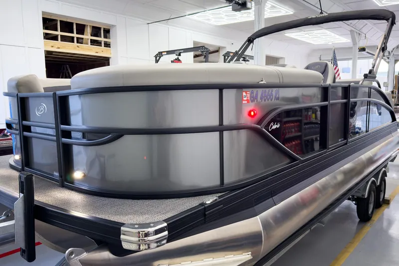 The Image of 2025 Barletta Cabrio 22UC pontoon boat in a showroom, showcasing sleek design and modern features. - 0