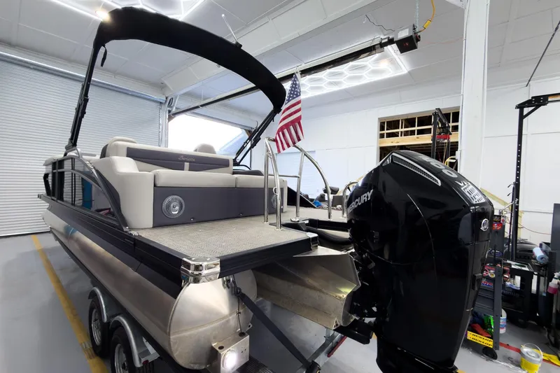 Slide: The Image of 2025 Barletta Cabrio 22UC pontoon boat with Mercury engine in a garage setting. - 3