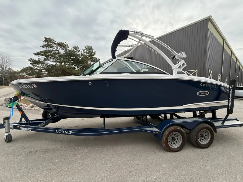 The Image of 2022 Cobalt CS23 Surf boat on trailer, side view. - 1