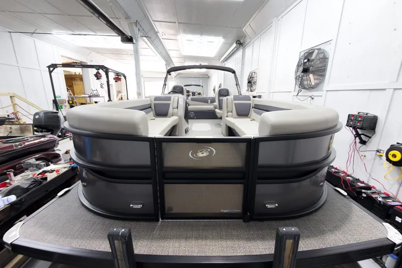 Slide: The Image of 2025 Barletta Cabrio 24UC pontoon boat in a workshop setting. - 2