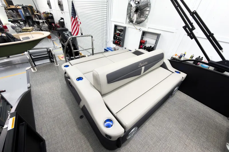 Slide: The Image of 2025 Barletta Cabrio 24UC pontoon boat interior with plush seating in a showroom. - 24
