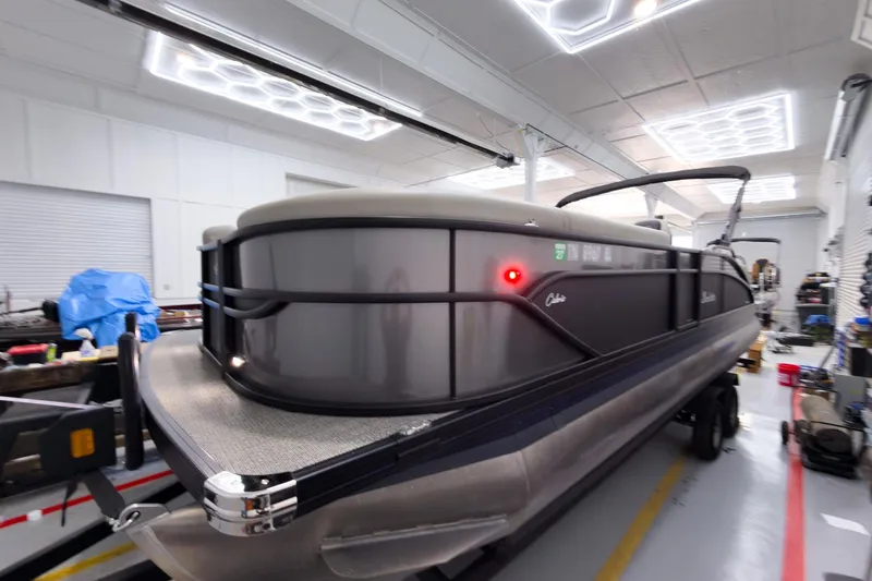 Slide: The Image of 2025 Barletta Cabrio 24UC pontoon boat in a well-lit showroom. - 3