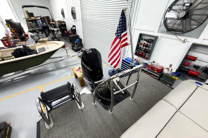 Slide: The Image of 2025 Barletta Cabrio 24UC in workshop with American flag and Mercury engine. - 31