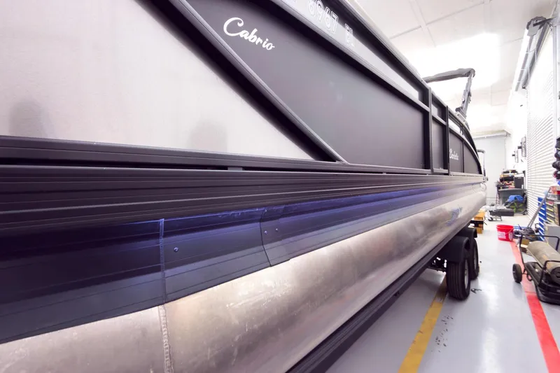 Slide: The Image of 2025 Barletta Cabrio 24UC pontoon boat in a workshop, side view. - 35