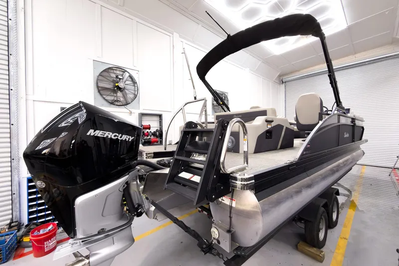 Slide: The Image of 2025 Barletta Cabrio 24UC pontoon boat with Mercury engine in a garage setting. - 6