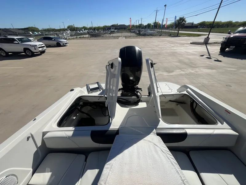 Slide: The Image of 2016 Tahoe 550 TS boat with open storage compartments and motor. - 20