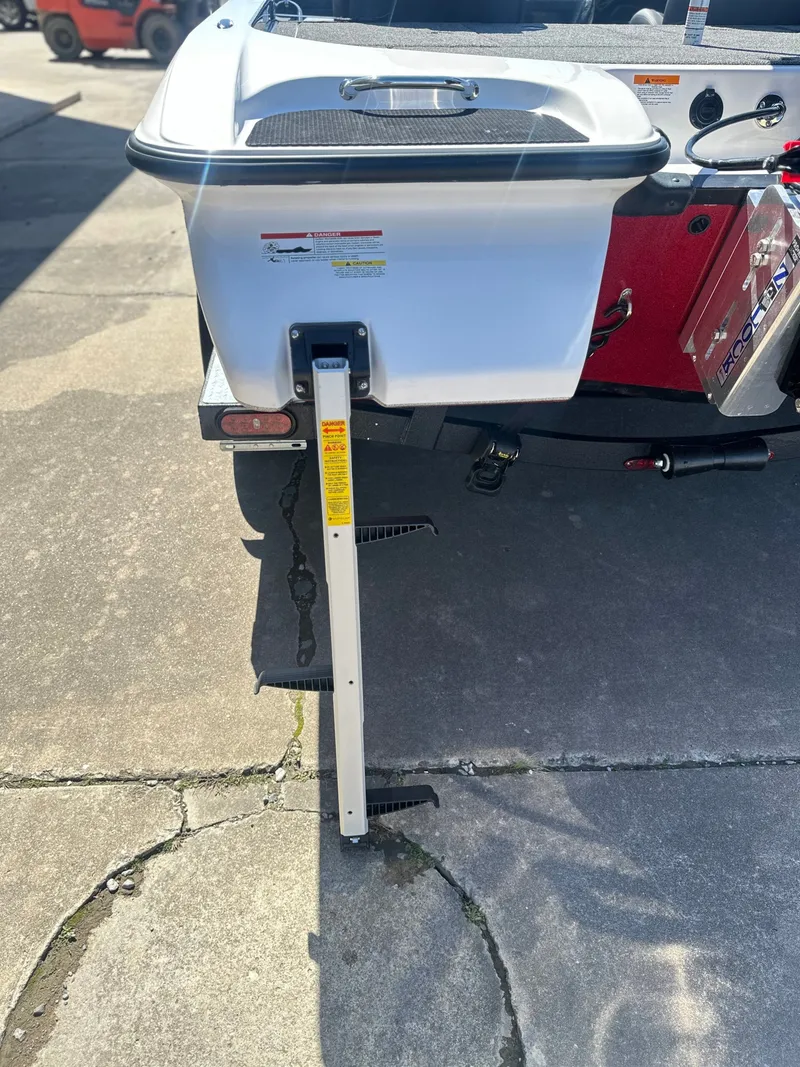 Slide: The Image of Caymas CX 201 PRO 2027 boat with support pole on concrete surface. - 4