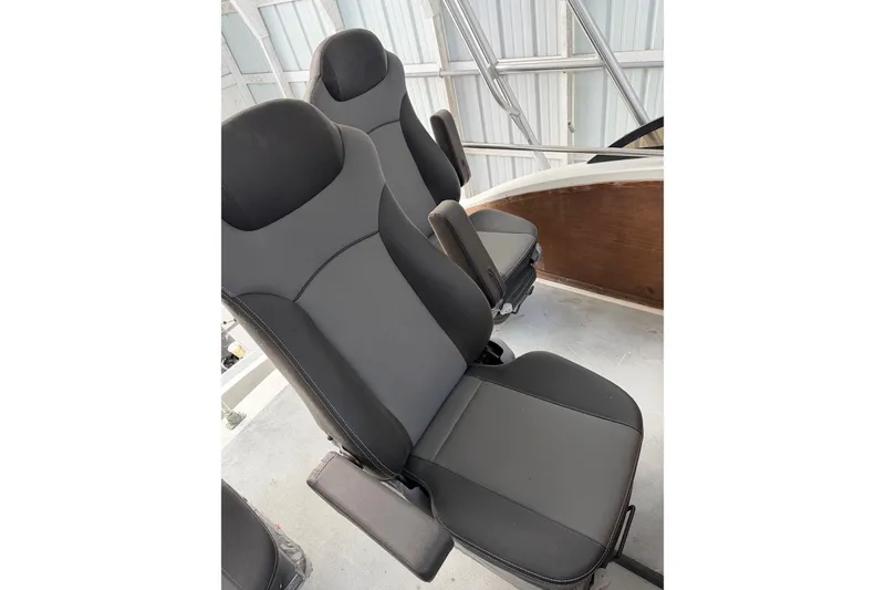 Slide: The Image of 1974 Magnum Sportfisher boat seats, black upholstery, in a metal-framed interior. - 10