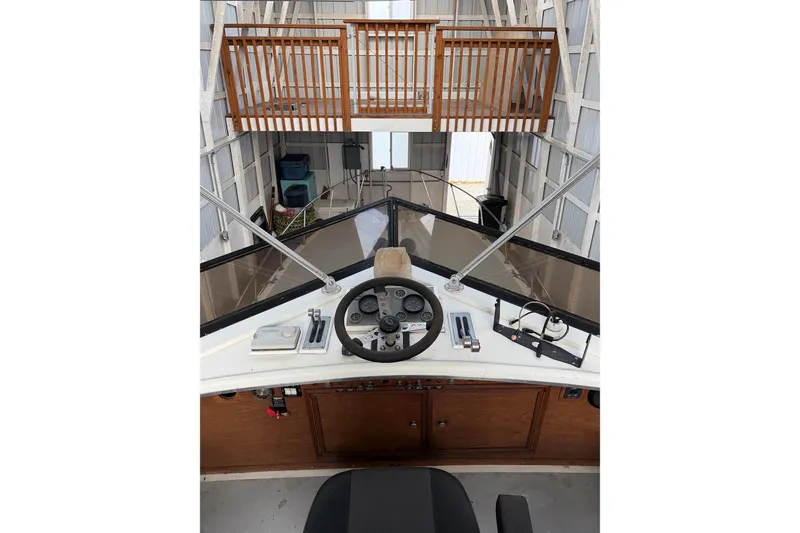 Slide: The Image of 1974 Magnum Sportfisher boat helm with steering wheel and controls in a docked setting. - 11