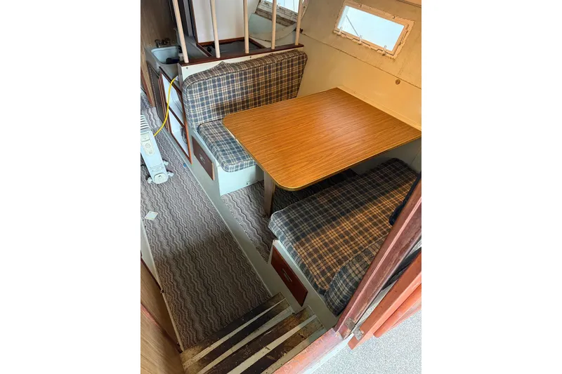 Slide: The Image of 1974 Magnum Sportfisher interior with plaid seating and wooden table in cozy cabin. - 15