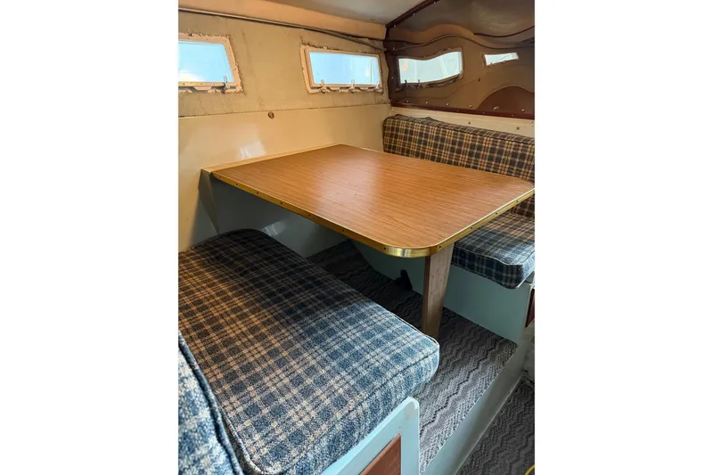 Slide: The Image of 1974 Magnum Sportfisher interior with plaid seating and wooden table. - 16