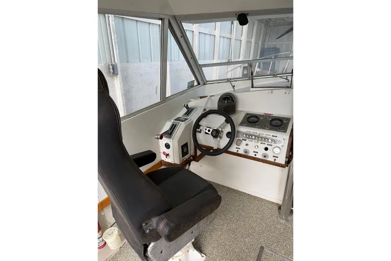 Slide: The Image of 1974 Magnum Sportfisher helm with steering wheel, control panel, and captain's chair. - 17