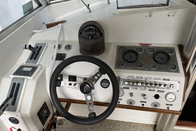 Slide: The Image of 1974 Magnum Sportfisher boat dashboard with steering wheel and control gauges. - 18
