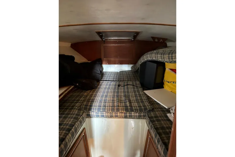 Slide: The Image of 1974 Magnum Sportfisher cabin interior with plaid upholstery and storage compartments. - 19