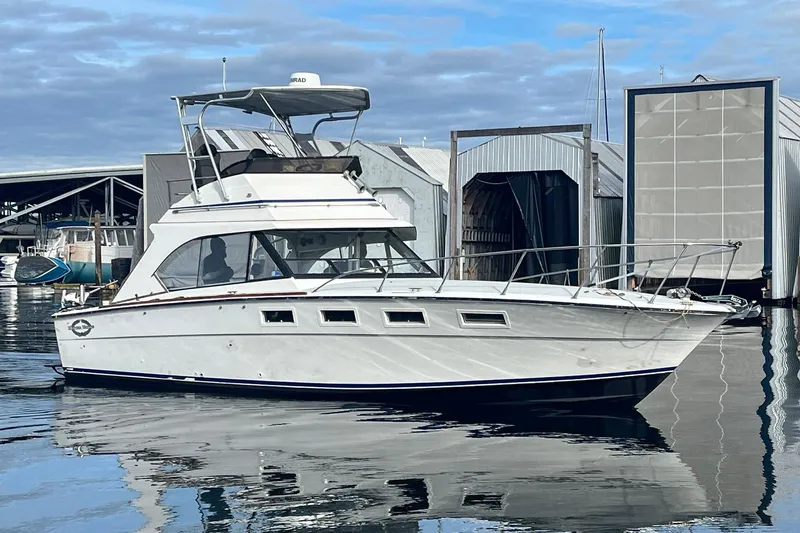 Slide: The Image of 1974 Magnum Sportfisher boat docked at marina with clear sky background. - 3