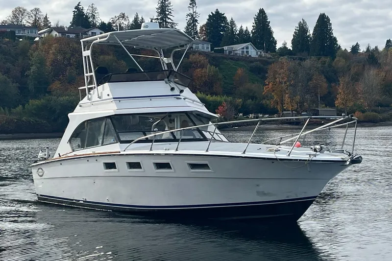 Slide: The Image of 1974 Magnum Sportfisher boat on a calm lake with autumn trees in the background. - 4