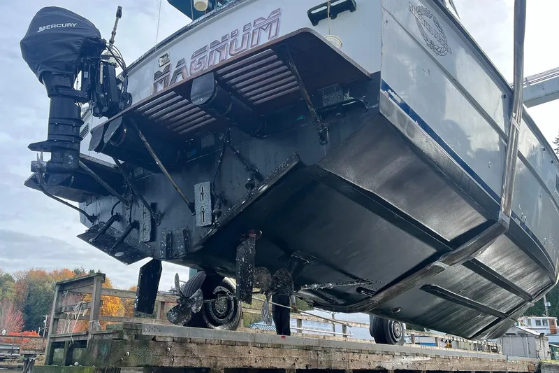 Slide: The Image of 1974 Magnum Sportfisher boat with Mercury engine, elevated for maintenance, showcasing hull and propeller. - 5