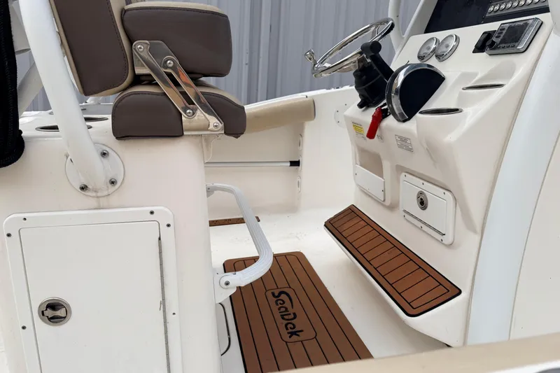Slide: The Image of 2018 Tidewater 232 SS boat interior with steering console and seating. - 12
