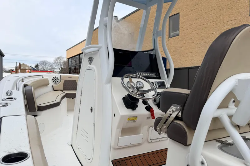Slide: The Image of 2018 Tidewater 232 SS boat interior with steering console and seating area. - 14