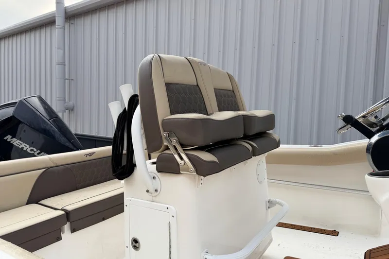 Slide: The Image of 2018 Tidewater 232 SS boat interior with cushioned seating and Mercury engine. - 15