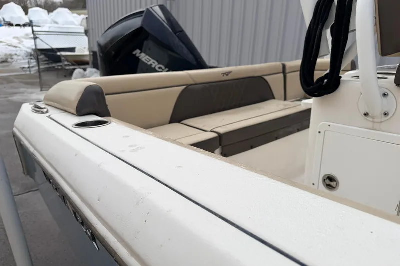 Slide: The Image of 2018 Tidewater 232 SS boat with beige seating and Mercury engine, docked outdoors. - 17