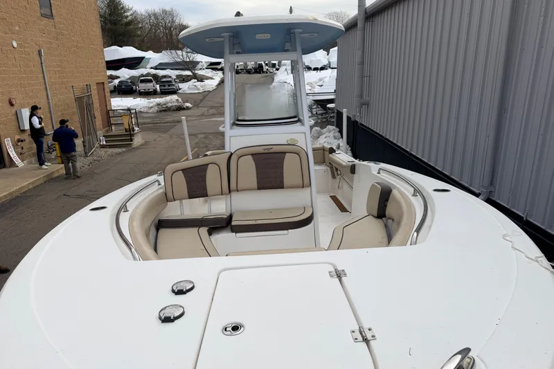 Slide: The Image of 2018 Tidewater 232 SS boat with spacious seating, docked near a building in snowy surroundings. - 19